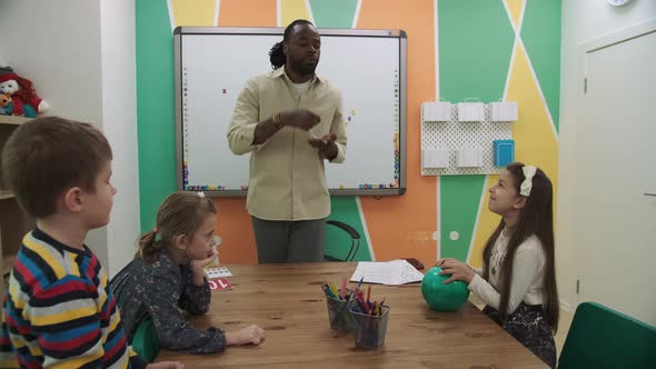 An African American Teacher Teaches a Group of People English at School