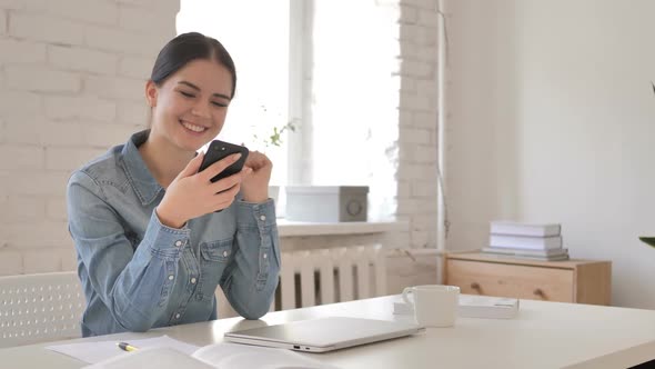 Young Girl Excited for Success While Using Smartphone