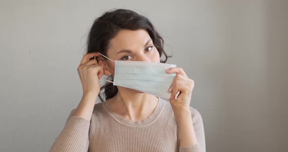 Young Woman Shows How To Wear Protective Medical Mask. Beautiful Girl Shows Protective Mask During