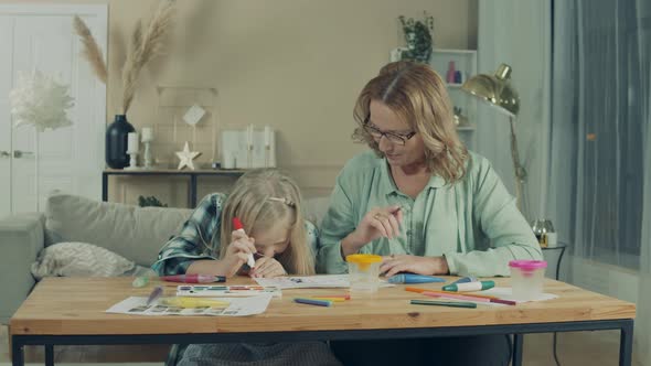 A Girl and Her Granny Are Drawing at Home Together