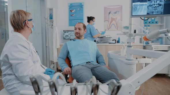 Stomatologist Showing Denture x Ray Results to Patient at Checkup Visit