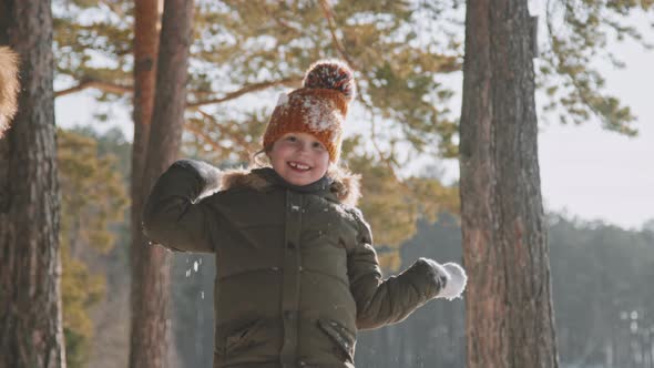 Portrait of Happy Little Girl Throwing Snow