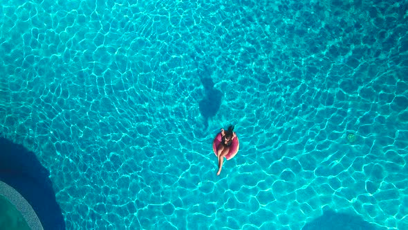 Girl on a circle swimming in the pool