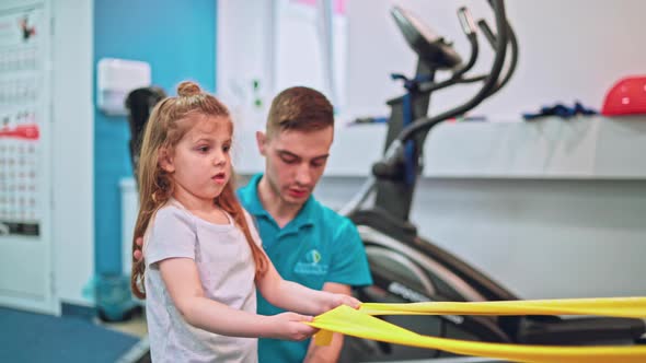 Young Girl Doing Exercises Under Physiotherapist Supervision alt