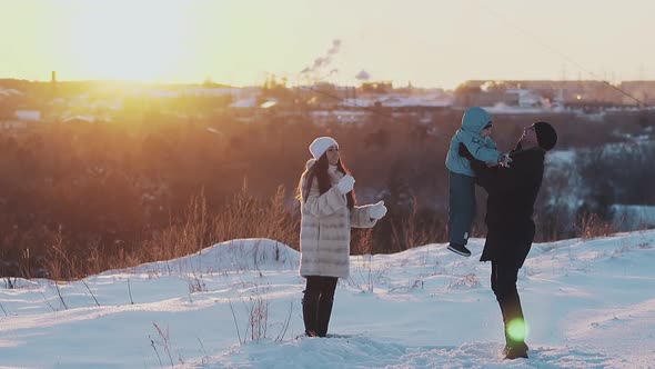Exciting Family Relaxes on Snowy Lawn at Sunset Slow Motion