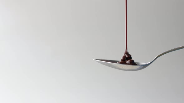 Dark Chocolate Cream Pouring on Spoon