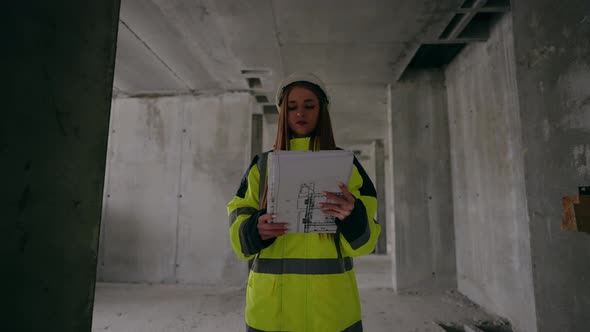 Young Female Civil Engineer is Walking in Building Under Construction Portrait