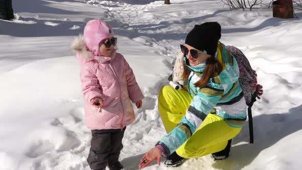 Mom with a Three-year-old Daughter Feeds Birds