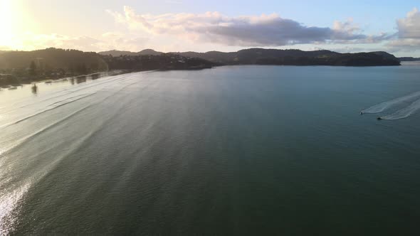 Sunset along New Zealand coastline with calming waves rolling in