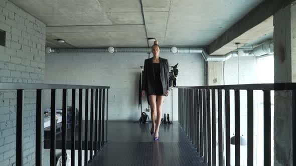Female Model Walks Along Dark Catwalk in Her Shoes at Home and Shows an Outfit