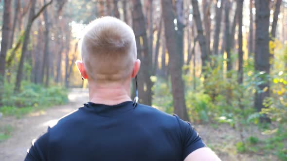 Unrecognizable Man Running Along Forest Path