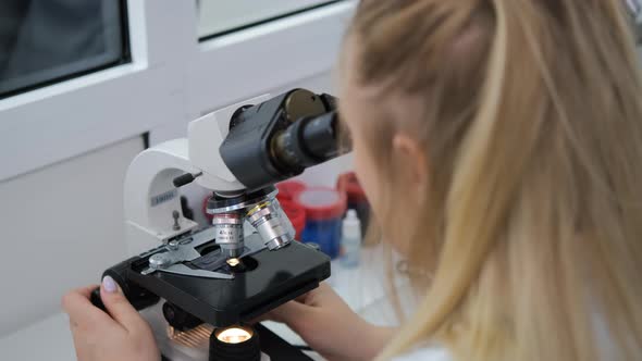 Lab Technician Analyzing Samples with Microscope