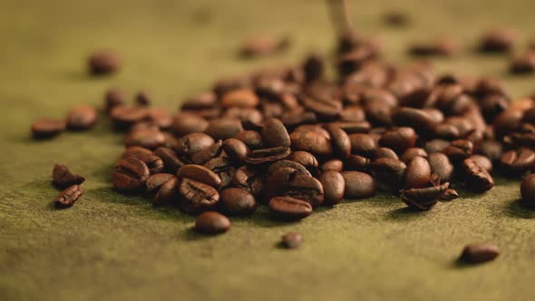 Roasted coffee beans falling down in golden light