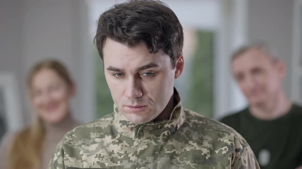 Closeup Portrait of Sad Handsome Recruit Looking at Camera with Depressed Facial Expression As