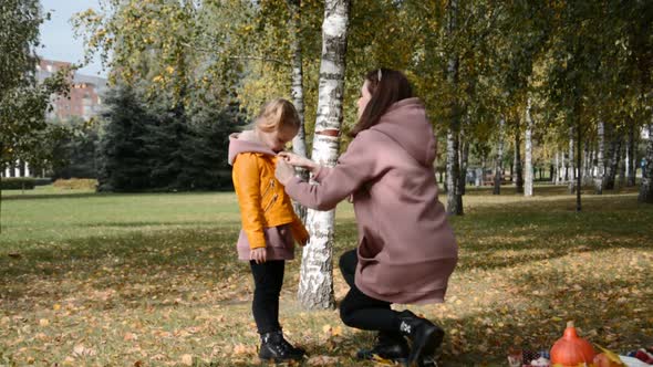 Maternal Care Concept Mom and Little Daughter are Playing in the Park