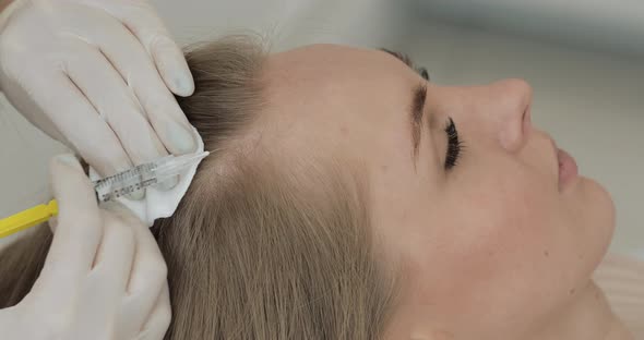 Young Attractive Woman Receives Mesotherapy for Hair. Girl Receives an Injection in the Head