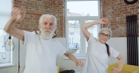 Senior Couple in Sportswear Doing Stretching Exercises with tilts Left to Right