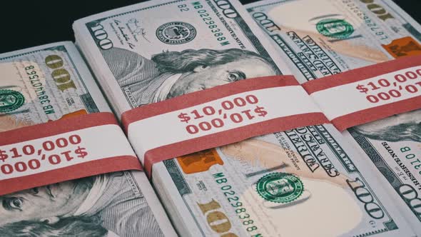 Bundles of Dollars Lying on a Pile of Money and Rotate on Black Background