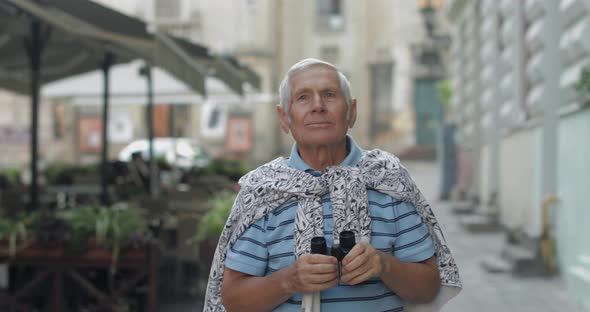 Senior Man Tourist Exploring Town. Looking in Binoculars. Travel Lviv, Ukraine