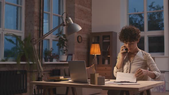 Woman Talking on Phone and Working at Home