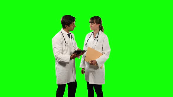 Front view doctors checking their results on digital tablet with green screen