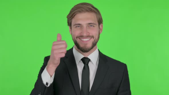 Thumbs Up By Young Businessman on Green Background