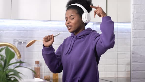 African American Black Handsome Woman Cooking Dancing with Headphones Enjoy Life Listening Favourite