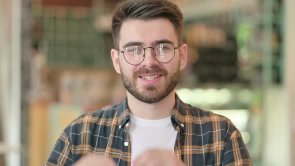 Portrait of Happy Young Man Showing Heart Sign By Hand 