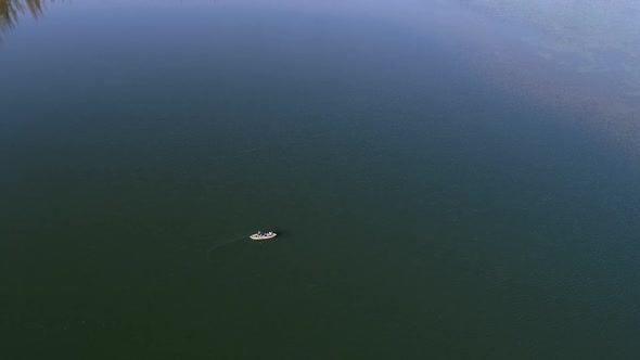 Aerial view tilting up past person on kayak to view the horizon