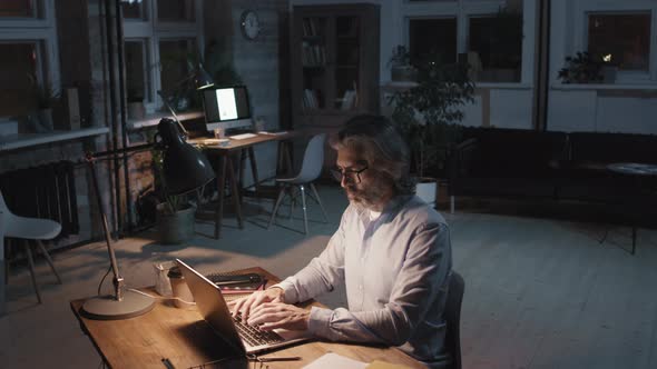 Man Working Alone In Office At Night