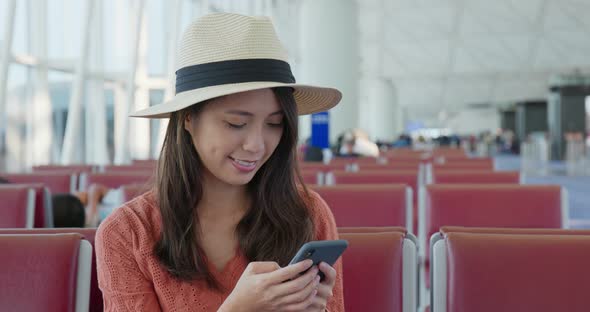 Woman work on cellphone in the airport