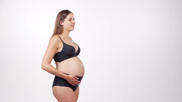 Young, happy and healthy pregnant woman in front of white background.