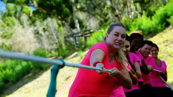 Group of women playing tug of war during obstacle course