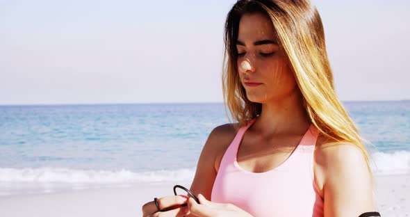 Fit woman putting earphones in her ear before jogging