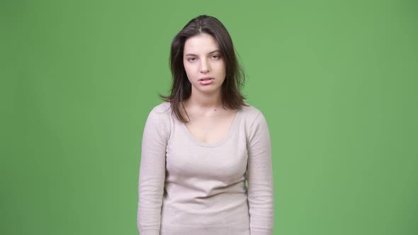 Young Beautiful Woman Looking Bored Against Green Background