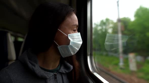 A Close-up Portrait of a Dark-haired, Middle-aged Woman Wearing a Medical Mask. She Is Riding the