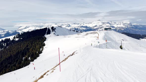 Ski Slope with Skiers Go Down in French Alps Valley