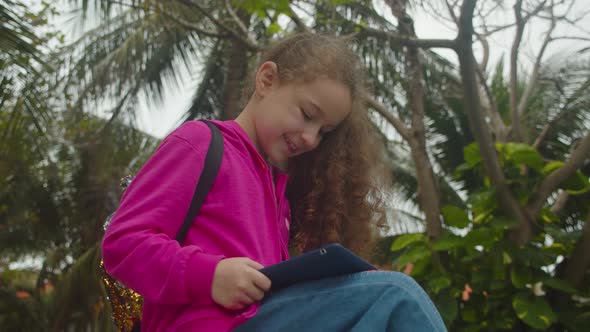 Cute Little Girl Child Using a Digital Tablet Technology Device Telephone or Laptop