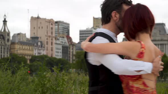 A couple of tango performers dancing closely while holding hands passionately in Downtown Buenos Air