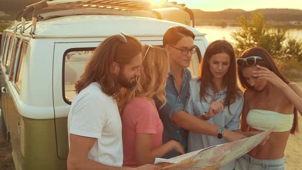 Summer Travel. Friends Using Map Near Car In Nature. Happy Smiling People Traveling 