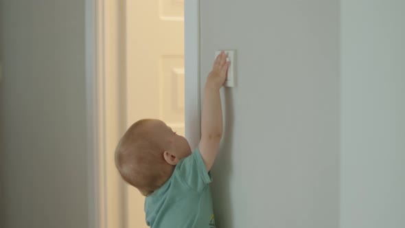 Little Baby Toddler Child Switching on Light in Room Kid Turn on Switch on Wall