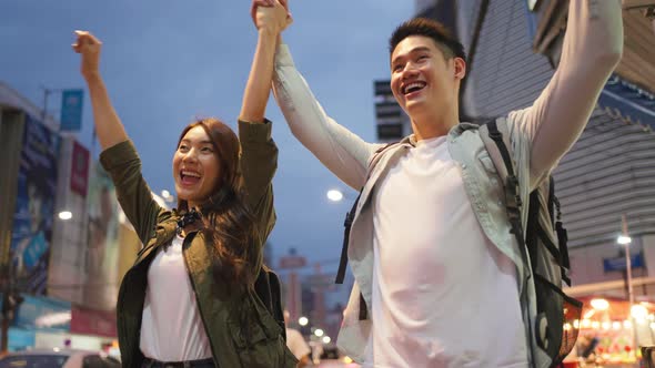 Asian active young couple travel in city for honeymoon trip at night.