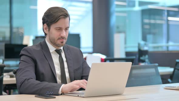 Businessman Working on Laptop in Office