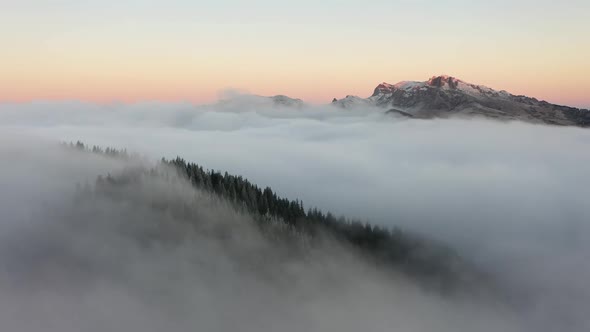 Spectacular Flight Through Clouds Over The Forested Mountain At High Altitude