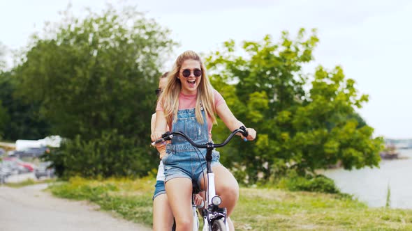 Teenage Girls or Friends Riding Bicycle in Summer