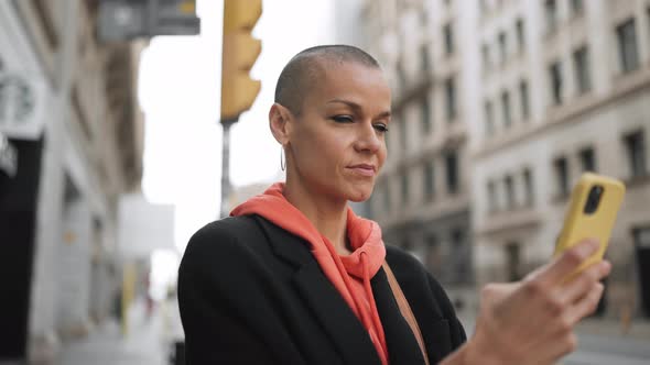 Meditative bald woman texting by phone