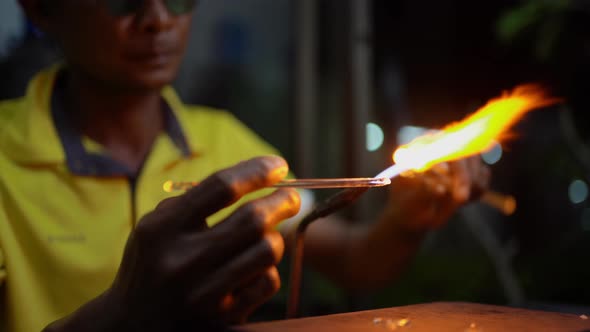 Senior man forming melted glass