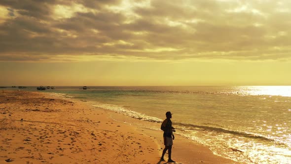 Male model fisherman on exotic seashore beach time by blue green ocean with white sandy background o