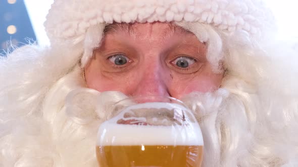 Old Santa Claus Drinks Delicious Beer From a Glass Opens His Eyes in Surprise