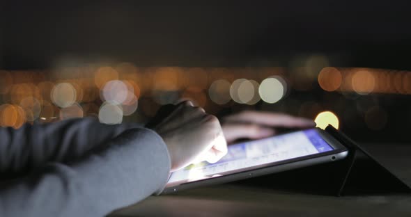 Woman Typing on Digital Tablet at Night 